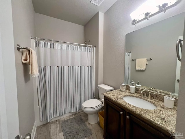 bathroom with vanity, toilet, a textured ceiling, and a shower with shower curtain