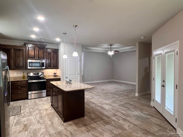 kitchen featuring a center island, stainless steel appliances, decorative light fixtures, dark brown cabinetry, and ceiling fan