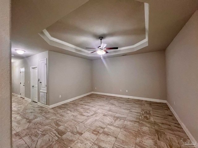 unfurnished room with a tray ceiling and ceiling fan