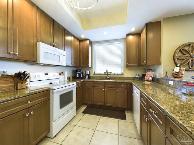 kitchen featuring recessed lighting, light tile patterned flooring, white appliances, a raised ceiling, and a sink