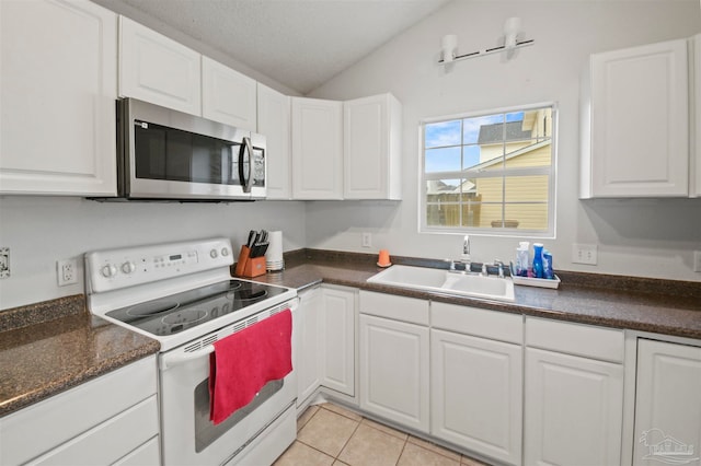 kitchen featuring white cabinets, sink, vaulted ceiling, and electric range