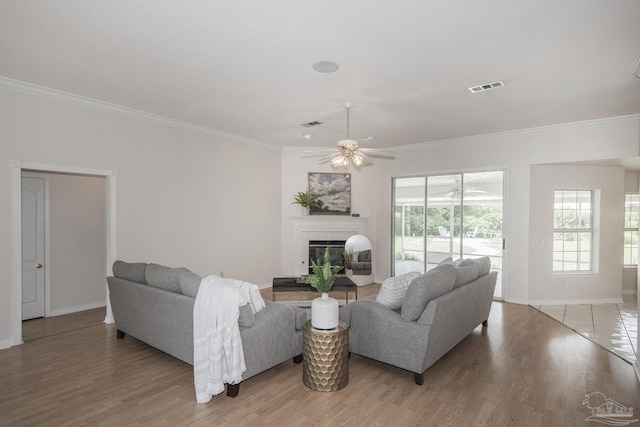 3221 Cobblestone Dr, Pace, FL 32571 - living area with a ceiling fan, crown molding, a tile fireplace, baseboards, and light wood-style floors