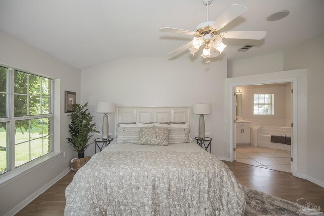 3221 Cobblestone Dr, Pace, FL 32571 - bedroom with vaulted ceiling, wood finished floors, ensuite bathroom, baseboards, and a ceiling fan