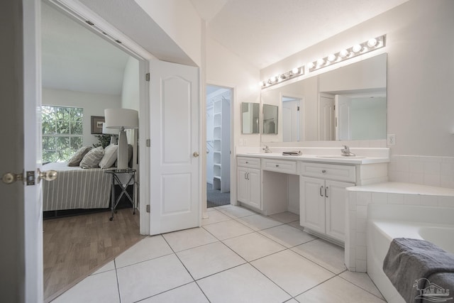 3221 Cobblestone Dr, Pace, FL 32571 - ensuite bathroom with a garden tub, lofted ceiling, double vanity, wood finished floors, and a closet