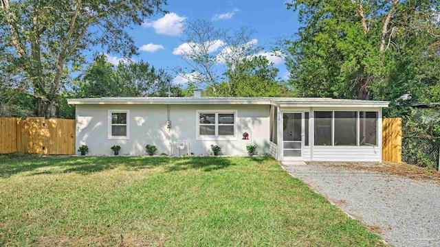 ranch-style home with a front yard and a sunroom