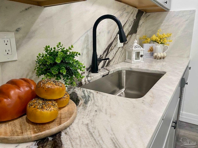 interior details featuring white cabinetry and sink