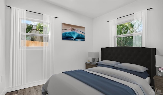 bedroom with multiple windows and hardwood / wood-style floors