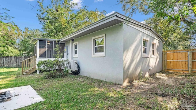 back of house with a yard and a sunroom