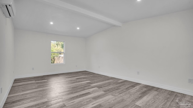 unfurnished room featuring a wall mounted AC, lofted ceiling with beams, and light wood-type flooring