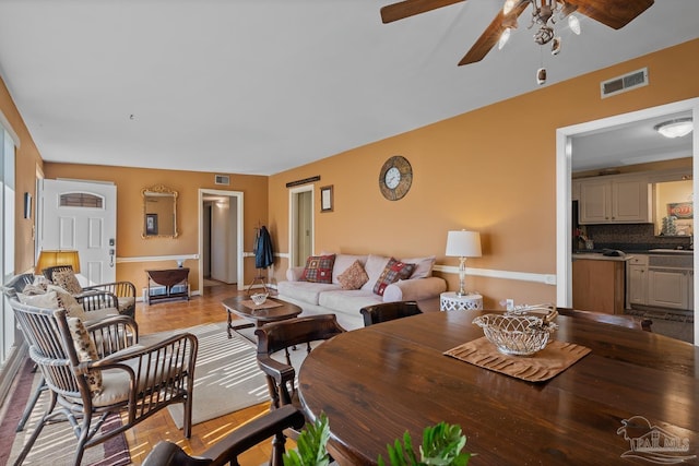 living room featuring a ceiling fan and visible vents