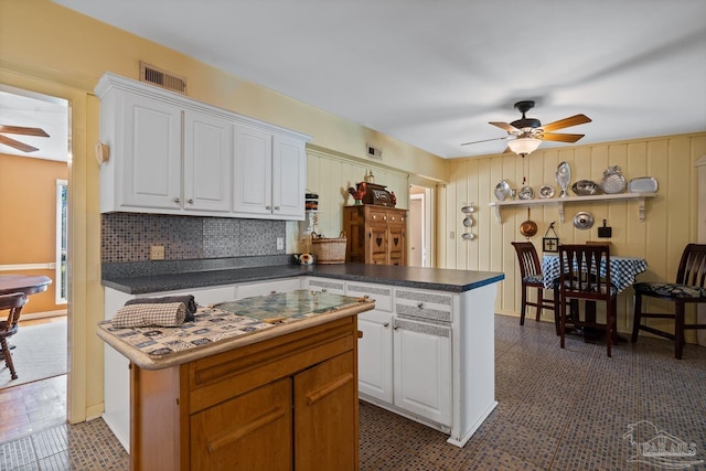 kitchen featuring dark countertops, visible vents, white cabinets, ceiling fan, and a peninsula