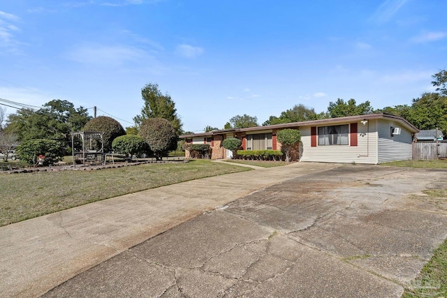 ranch-style house featuring driveway and a front lawn