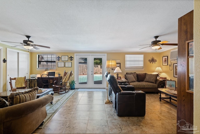 living room featuring a ceiling fan, french doors, tile patterned floors, crown molding, and a textured ceiling