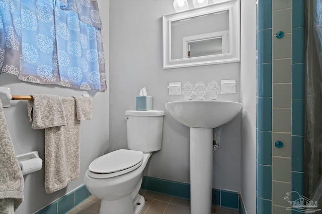 bathroom featuring baseboards, toilet, and tile patterned floors