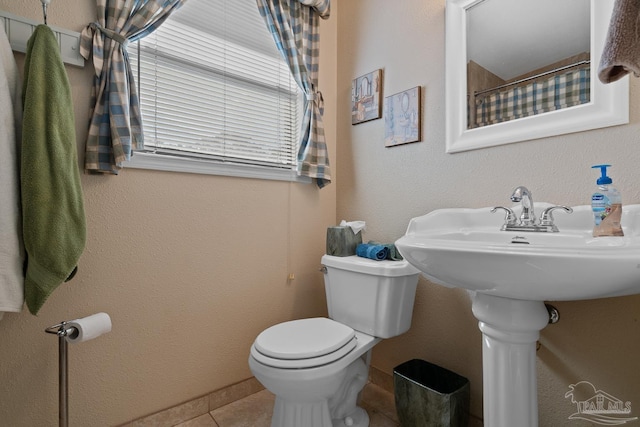 full bath with toilet, tile patterned flooring, and a sink