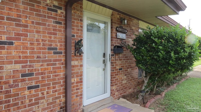 view of exterior entry featuring brick siding