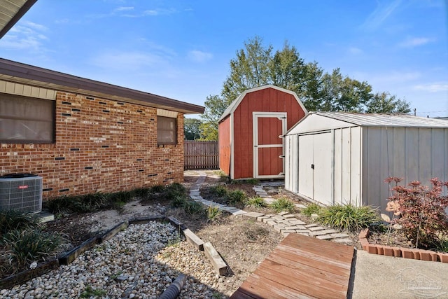 view of shed with fence and central AC unit