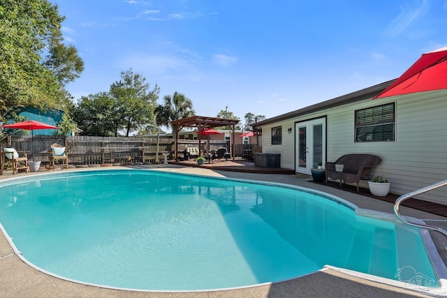 view of pool with a gazebo, a fenced backyard, a fenced in pool, and french doors