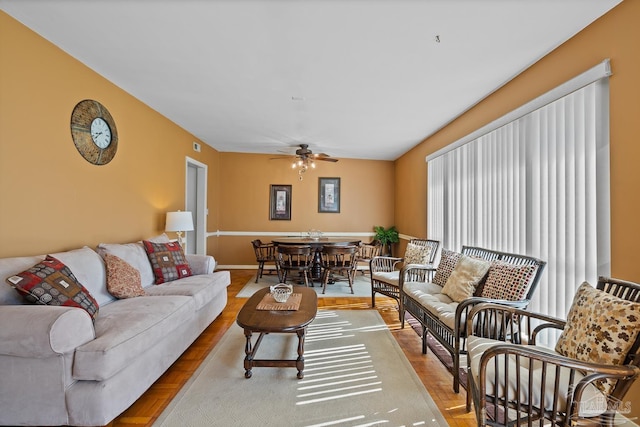 living area with ceiling fan, wood finished floors, and baseboards