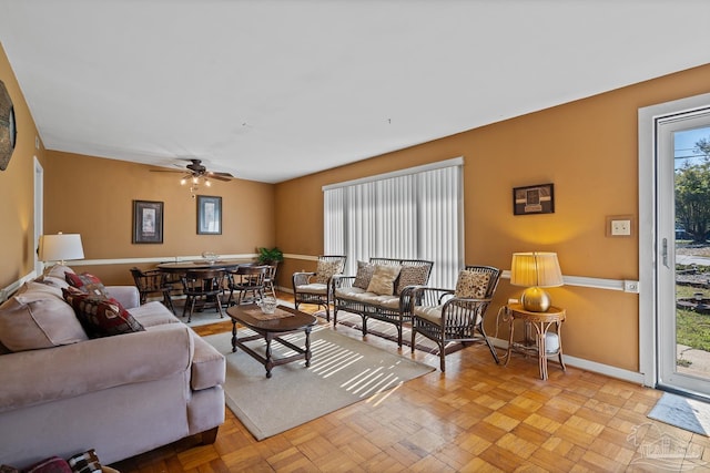 living room featuring ceiling fan and baseboards