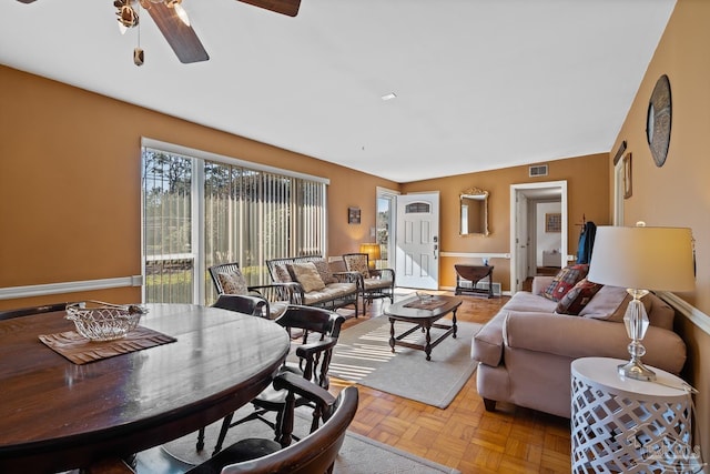 living area featuring a ceiling fan, visible vents, and baseboards