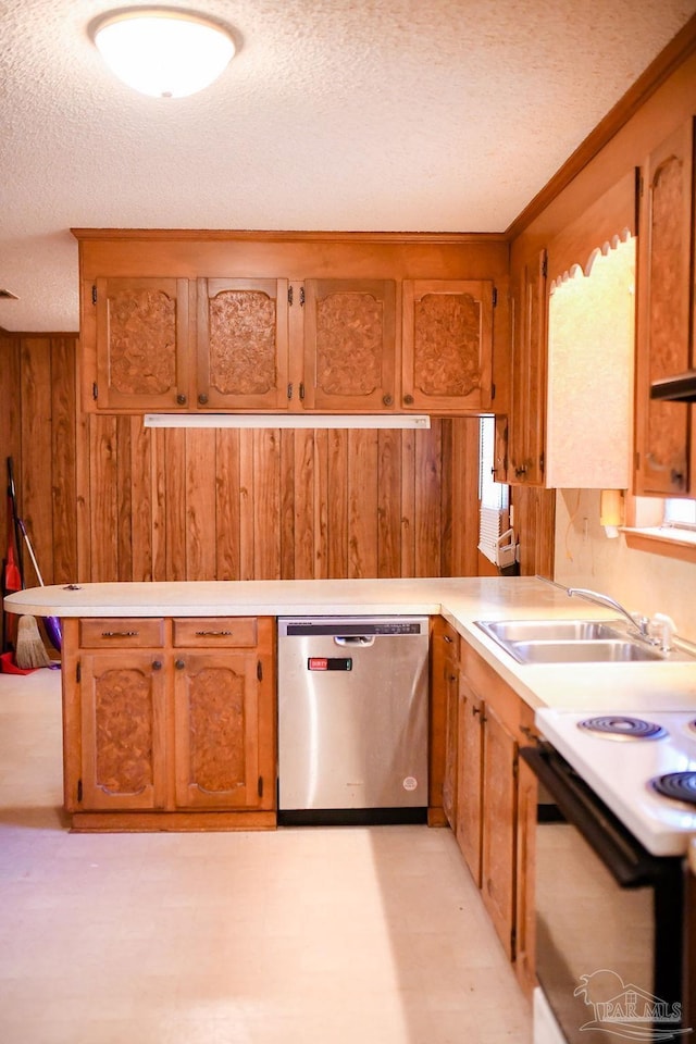 kitchen featuring sink, stainless steel dishwasher, wood walls, a textured ceiling, and range