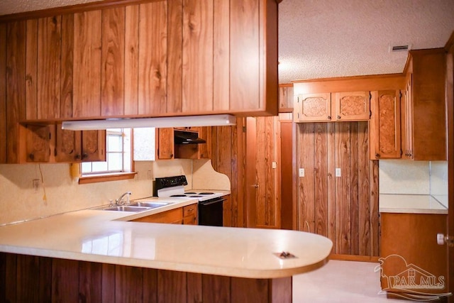 kitchen with kitchen peninsula, sink, a textured ceiling, and white electric range