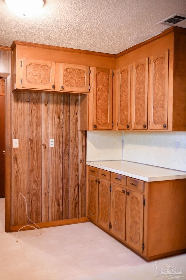 kitchen featuring a textured ceiling and wood walls