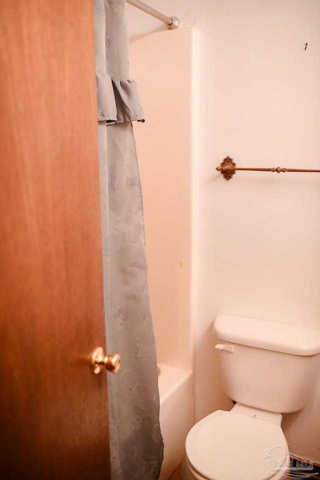 bathroom featuring toilet and shower / bath combo with shower curtain