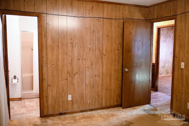 interior space featuring crown molding and wooden walls