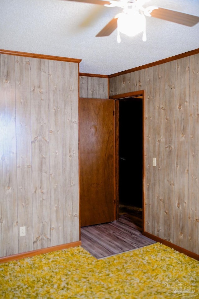 spare room with a textured ceiling, ceiling fan, and crown molding