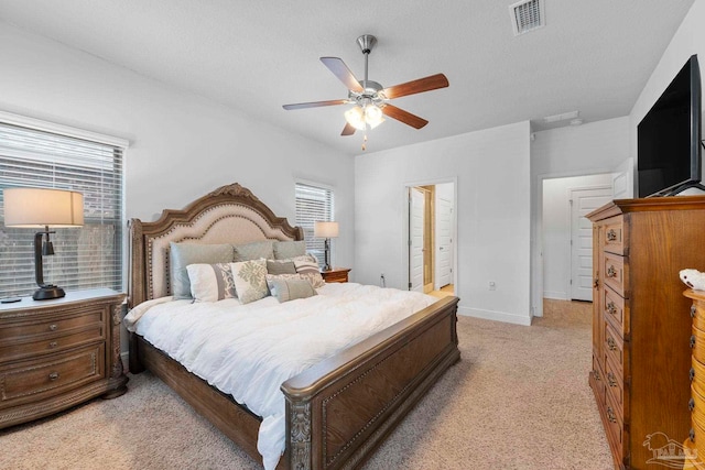 bedroom with visible vents, ceiling fan, baseboards, light carpet, and a textured ceiling