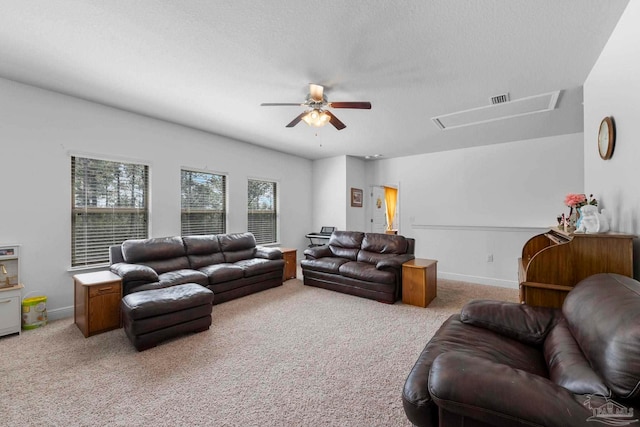 living room featuring baseboards, visible vents, attic access, ceiling fan, and light carpet