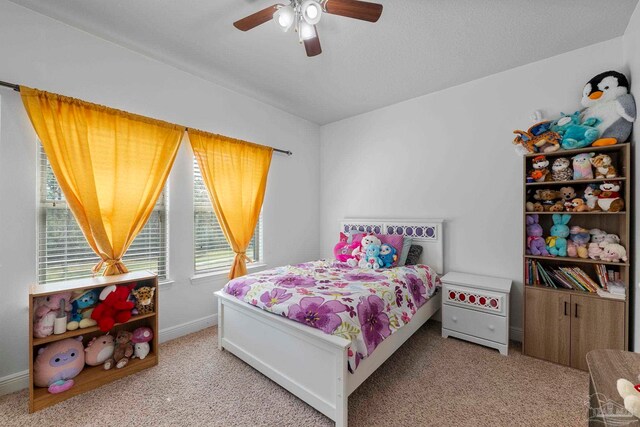 carpeted bedroom featuring baseboards and ceiling fan