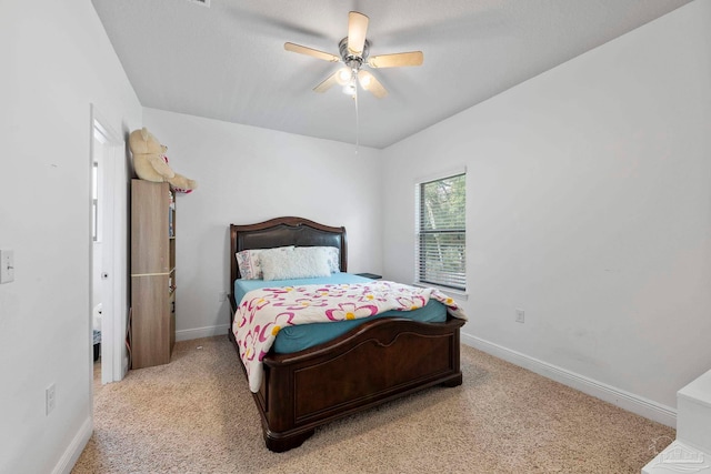 bedroom with light colored carpet, baseboards, and ceiling fan