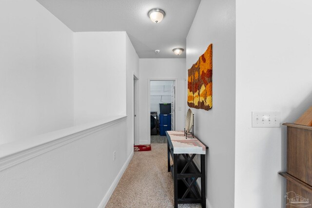 corridor featuring washer / clothes dryer, baseboards, and carpet floors