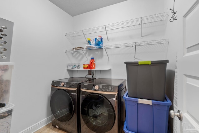 laundry area with laundry area, wood finished floors, separate washer and dryer, and baseboards