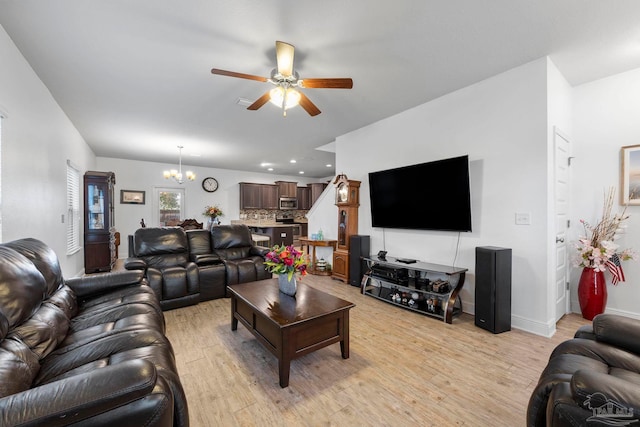 living area with recessed lighting, light wood-type flooring, baseboards, and ceiling fan with notable chandelier