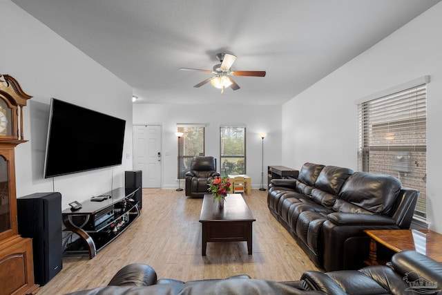 living room with light wood-type flooring, baseboards, and ceiling fan