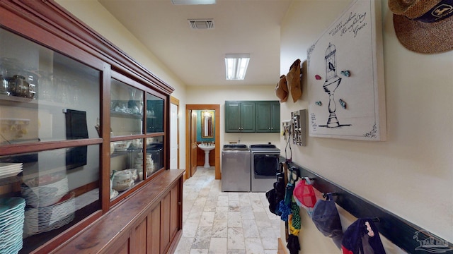 laundry area with light tile patterned flooring, cabinets, and washer and dryer