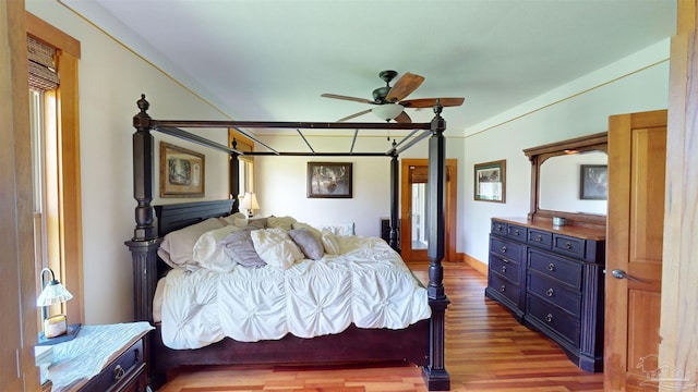 bedroom featuring ceiling fan, wood-type flooring, and ornamental molding