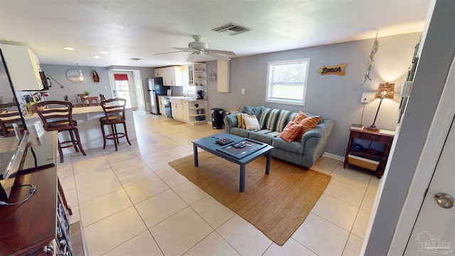 living room featuring ceiling fan, light tile patterned flooring, and plenty of natural light