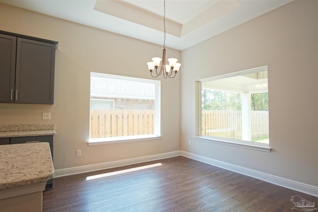 unfurnished dining area with an inviting chandelier, dark wood-style floors, and a healthy amount of sunlight