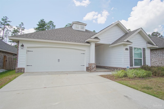 view of front of house with concrete driveway, a shingled roof, and brick siding