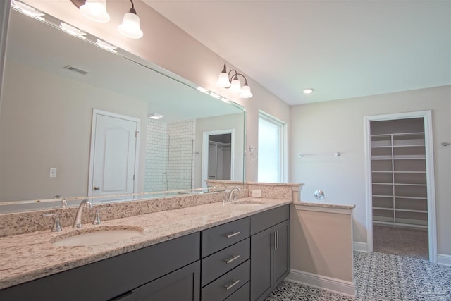 full bath featuring a stall shower, visible vents, a sink, and double vanity