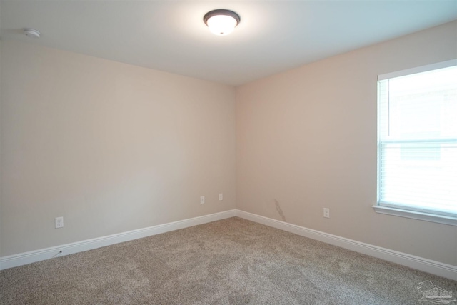 unfurnished room with baseboards and carpet