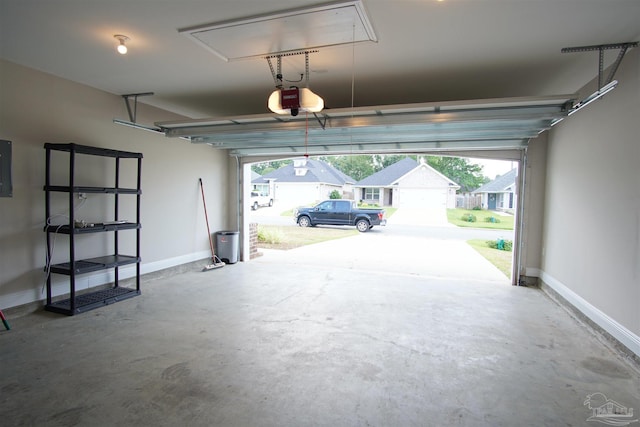 garage with baseboards, electric panel, and a garage door opener