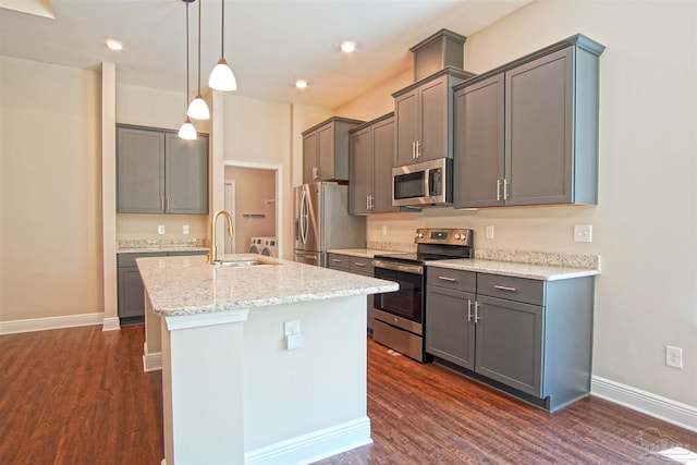 kitchen with stainless steel appliances, an island with sink, dark wood-type flooring, and a sink