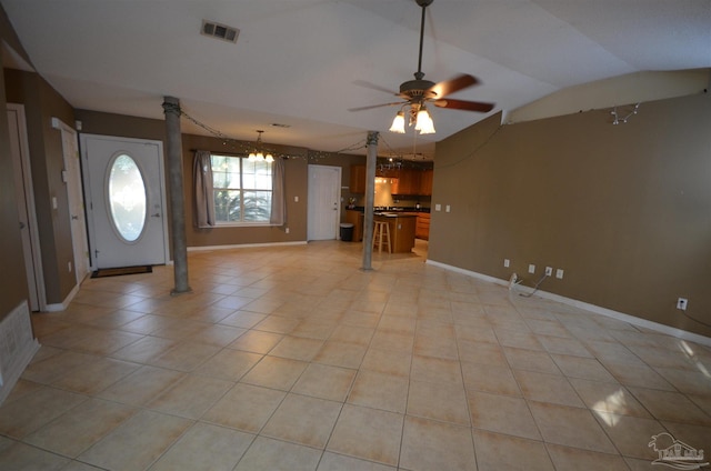 interior space with visible vents, baseboards, ceiling fan with notable chandelier, light tile patterned floors, and vaulted ceiling