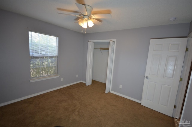 unfurnished bedroom with a closet, carpet flooring, baseboards, and a ceiling fan